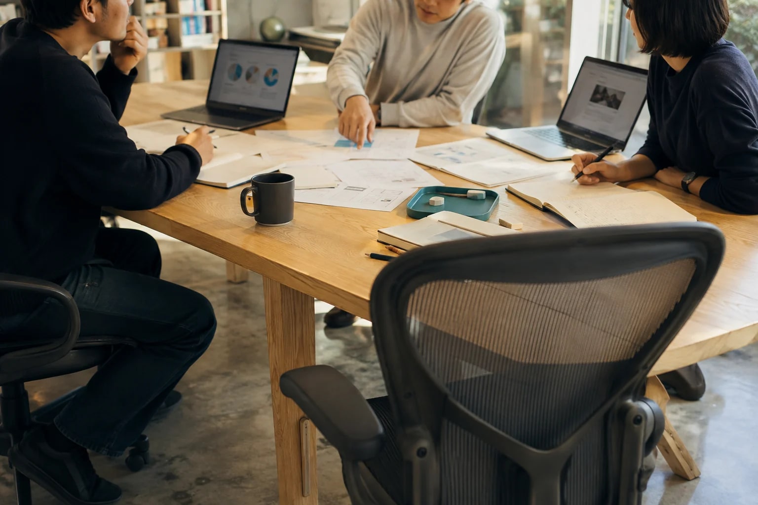 Empty chairs for colleagues sitting around a project table sharing ideas